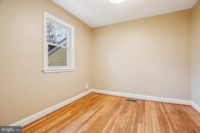 a view of a room with wooden floor and a window