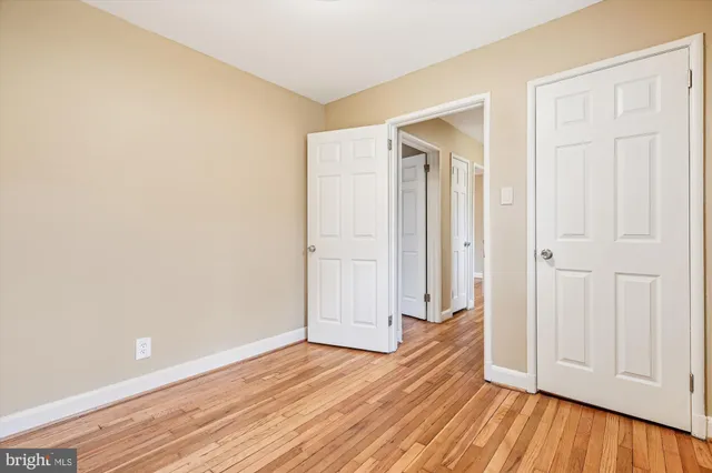 an empty room with wooden floor and closet area