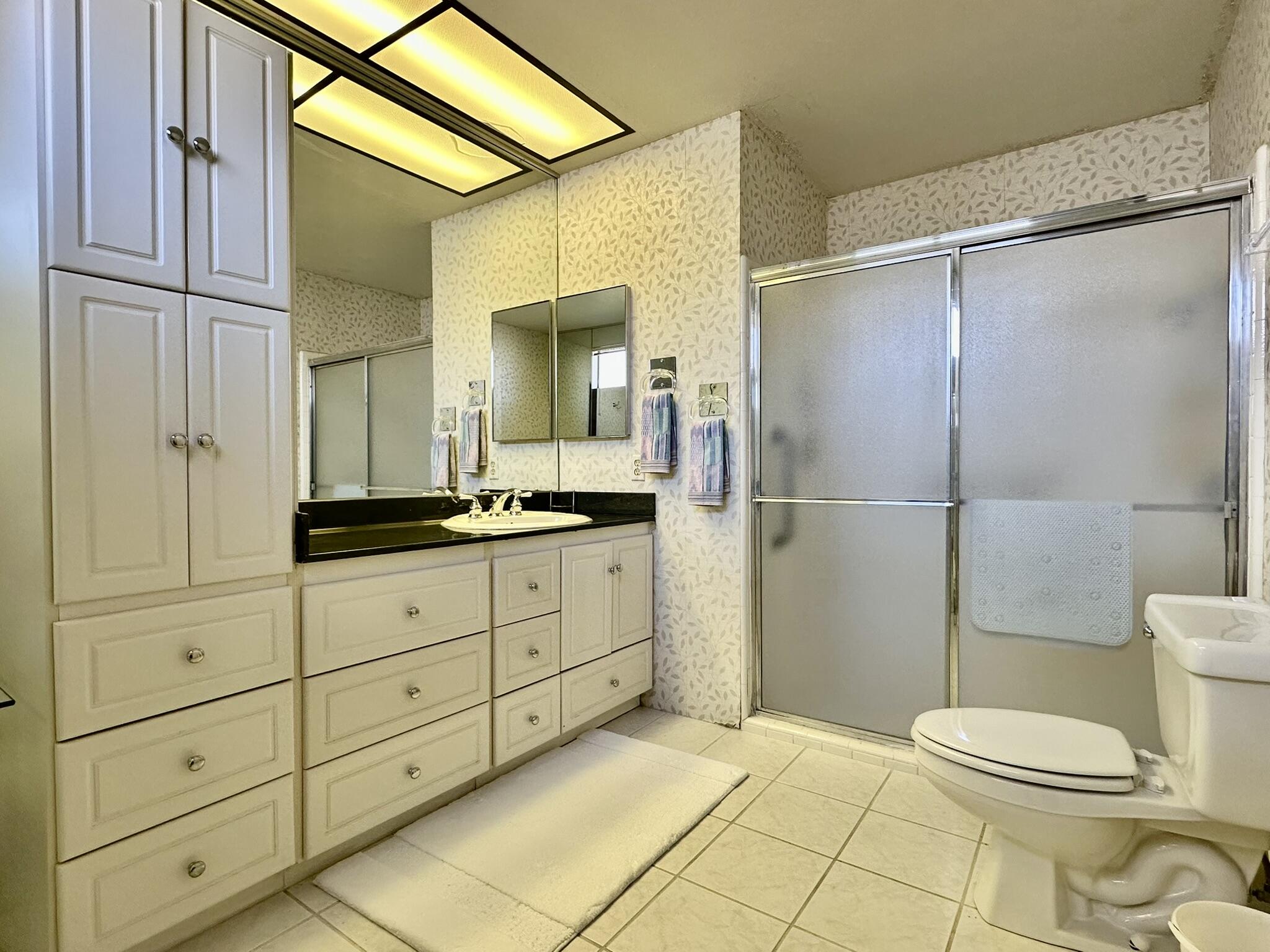 81 Marbella Drive Rancho Mirage, CA 92270 - Photo 15 of 17 a bathroom with a granite countertop sink toilet and shower