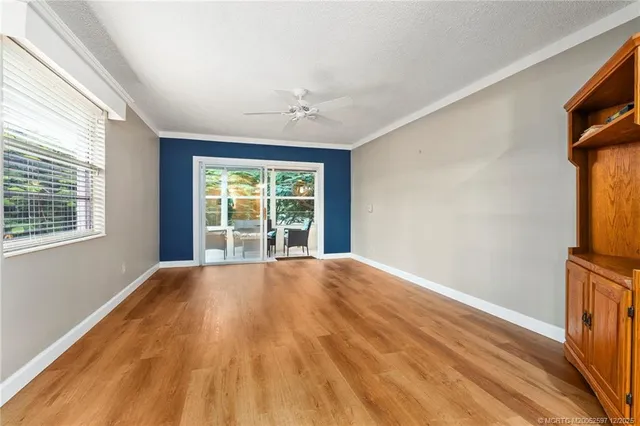 a view of a hallway with wooden floor and a window