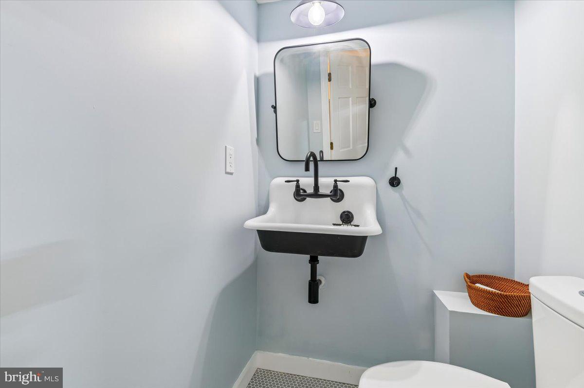 308 West Wind Road Towson, MD 21204 - Photo 51 of 80 a bathroom with a toilet sink and mirror