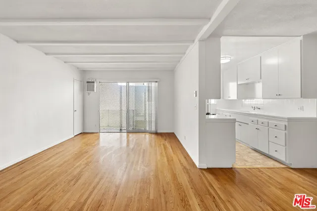 a view of a kitchen with wooden floor and electronic appliances