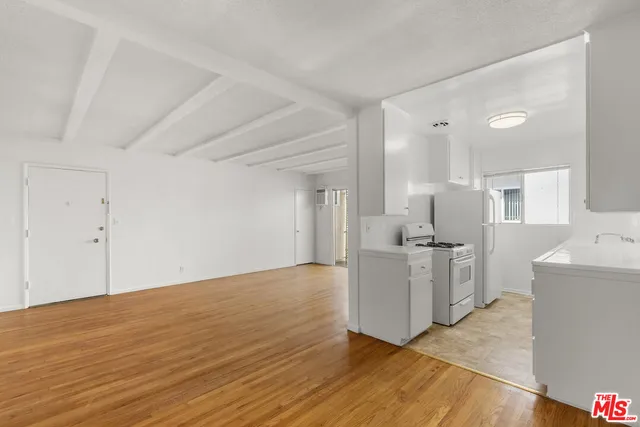 a kitchen with a sink cabinets and wooden floor