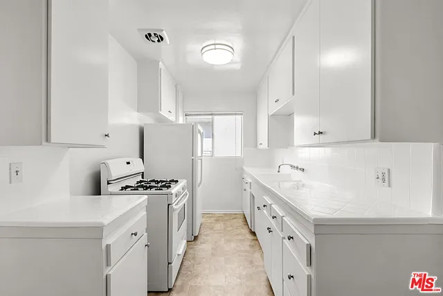 a kitchen with stainless steel appliances a sink stove and cabinets