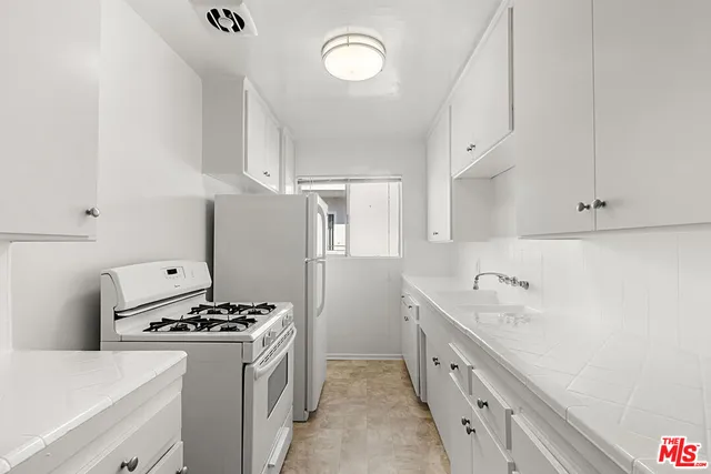 a kitchen with stainless steel appliances a sink a stove and a refrigerator