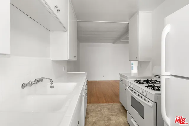 a kitchen with granite countertop a sink cabinets and stainless steel appliances