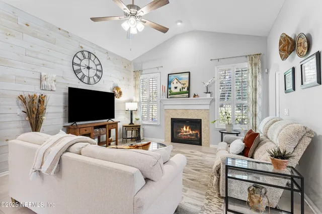 a living room with furniture a flat screen tv and a fireplace