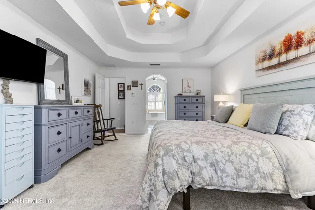 a spacious bedroom with a bed and a flat screen tv