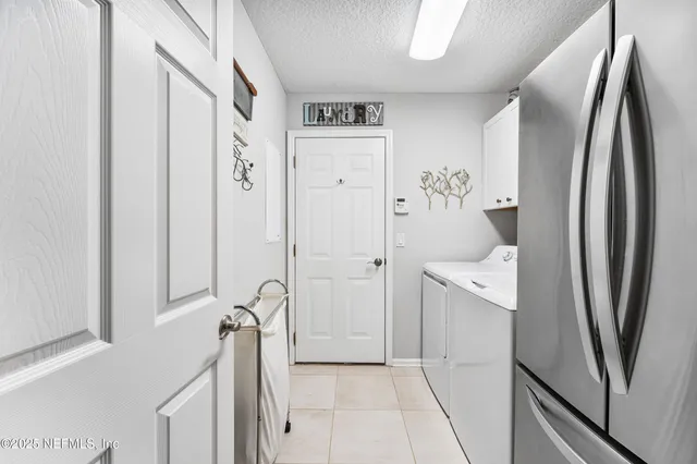 a view of a storage and utility room with refrigerator and mirror