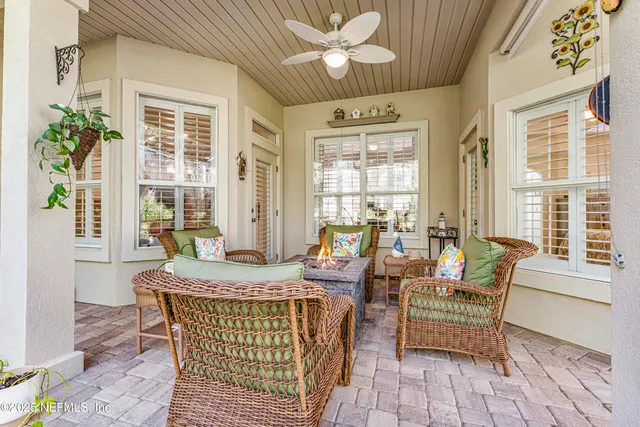 a living room with furniture and floor to ceiling windows