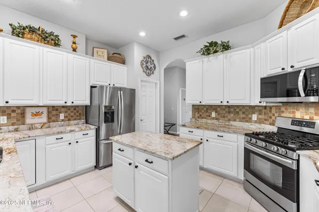 a kitchen with granite countertop a sink stove and refrigerator