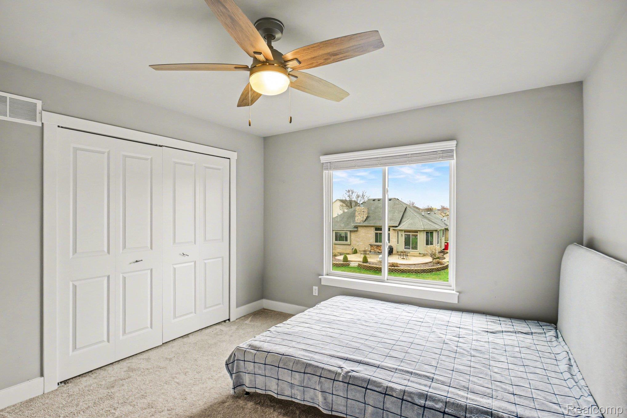 47705 Card Road Macomb, MI 48044 - Photo 31 of 53 Bright room featuring a window overlooking a manicured lawn and patio, light gray wall tones, and neutral carpet