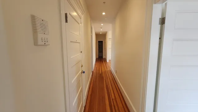 a view of a hallway with wooden floor and staircase
