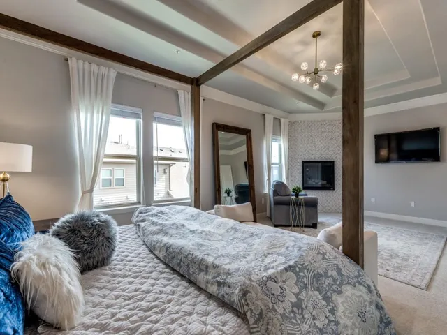 a bedroom with a large bed and a flat tv screen