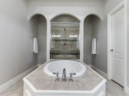 a bathroom with a granite countertop sink a mirror and shower