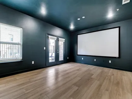 a view of an empty room with wooden floor and windows