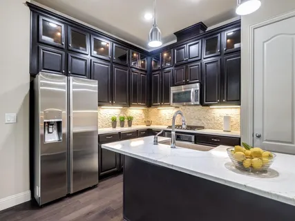 a kitchen with stainless steel appliances granite countertop a refrigerator and a sink