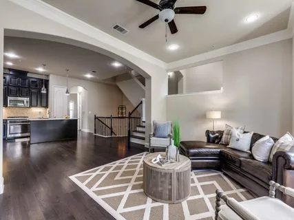 a living room with furniture and a dining table with wooden floor