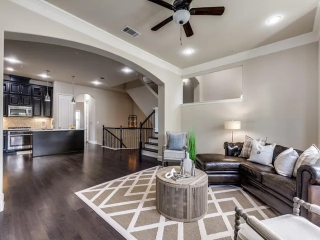 a living room with furniture and a dining table with wooden floor