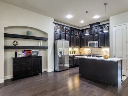 a kitchen with stainless steel appliances granite countertop a refrigerator and a stove