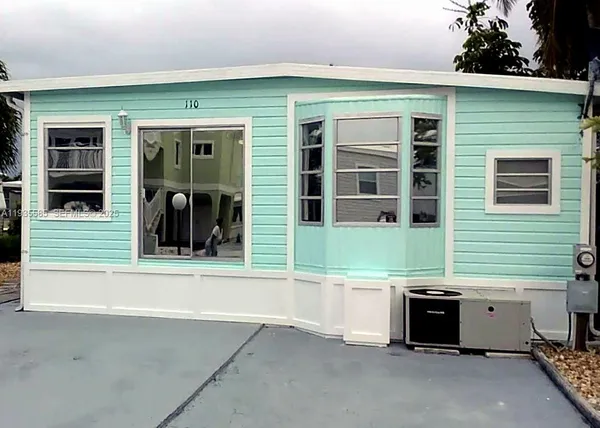 a view of a house with a barbeque and bench