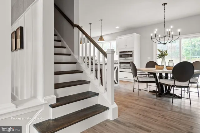 a view of a dining room with furniture a chandelier and wooden floor