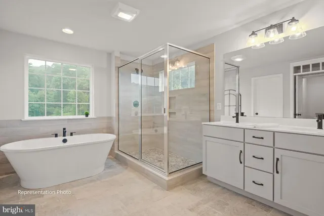a bathroom with a tub sink shower and mirror