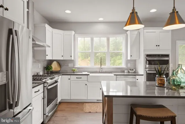 a kitchen with stainless steel appliances granite countertop a stove a sink and a refrigerator