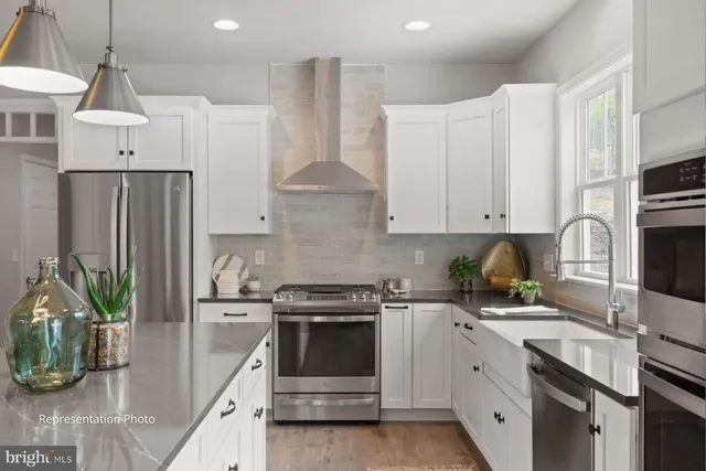 a kitchen with white cabinets and stainless steel appliances