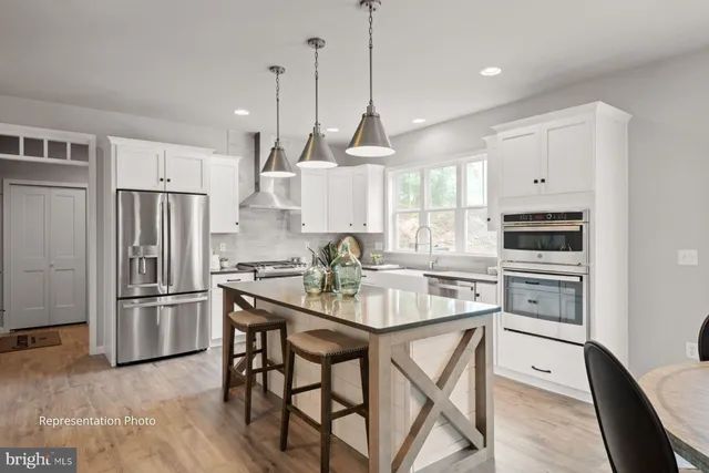 a kitchen with stainless steel appliances granite countertop a stove a refrigerator and a refrigerator