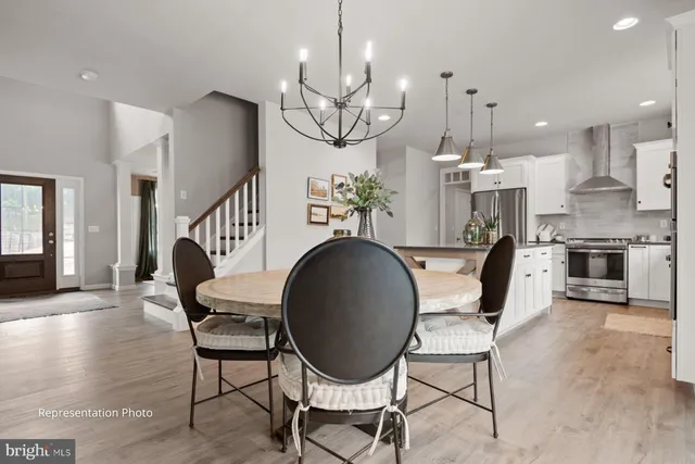 a dining room with furniture a chandelier and wooden floor