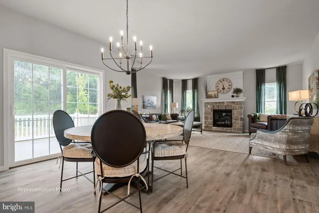 a living room with furniture a fireplace and a chandelier