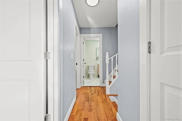 a view of a hallway with wooden floor and staircase