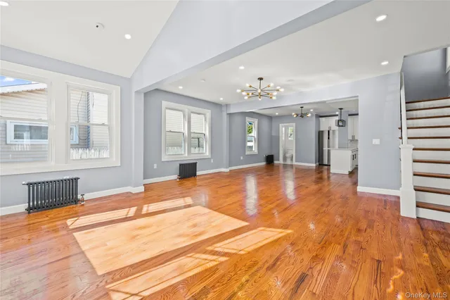 a view of a livingroom with wooden floor and kitchen space