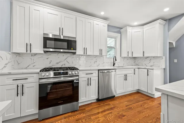 a kitchen with granite countertop a stove top oven microwave and cabinets