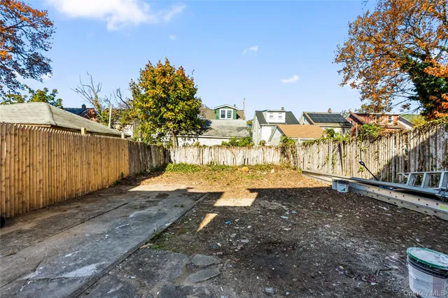 a view of a yard with wooden fence