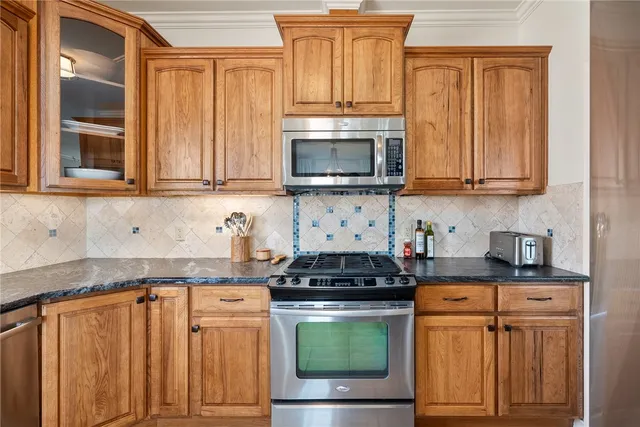 a kitchen with stainless steel appliances granite countertop a stove a sink and a microwave