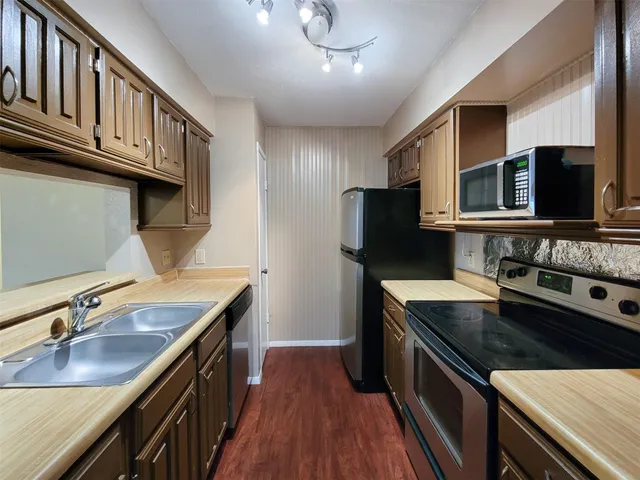 a kitchen that has a sink and a stove top oven