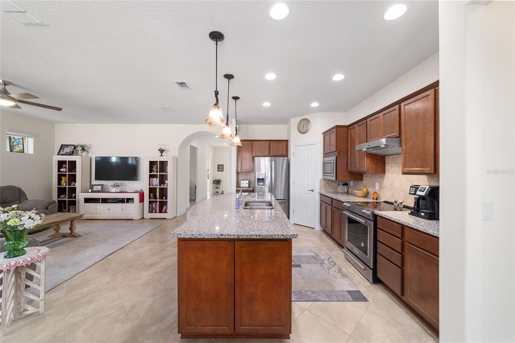 9603 Southwest 67th Street Ocala, FL 34481 - Photo 16 of 63 a large kitchen with stainless steel appliances kitchen island granite countertop a large counter top and stove