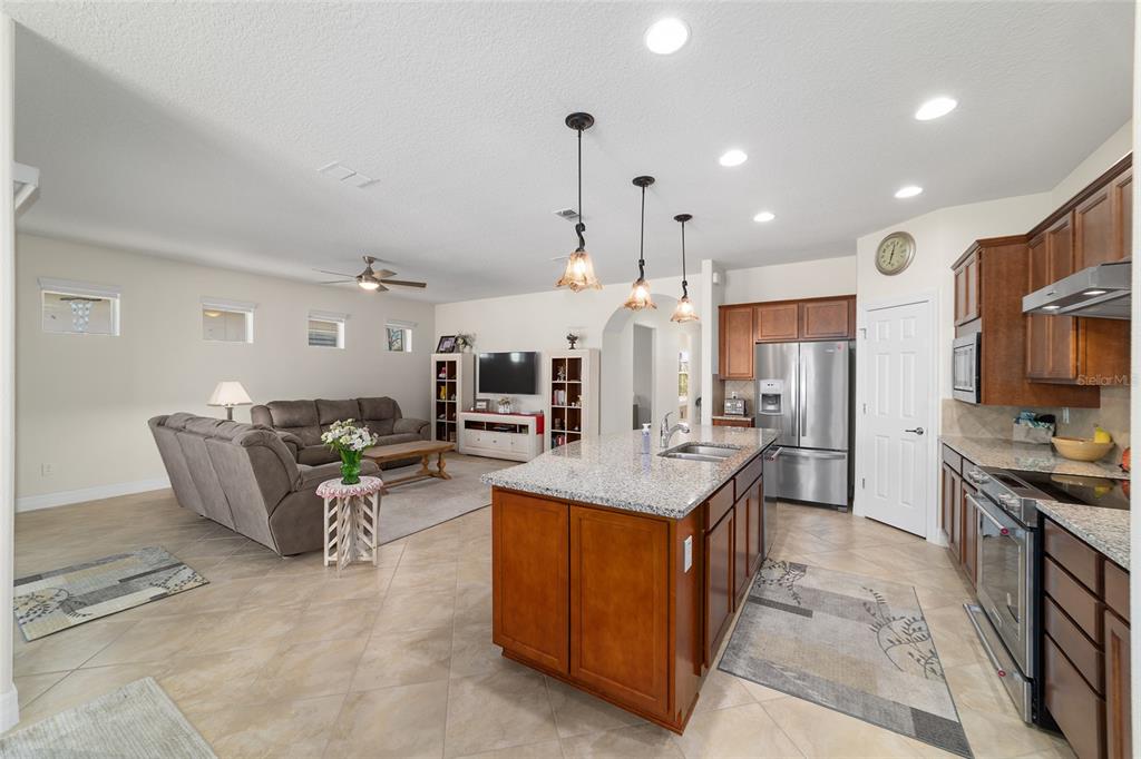 9603 Southwest 67th Street Ocala, FL 34481 - Photo 17 of 63 a large kitchen with stainless steel appliances kitchen island granite countertop a large counter top and stove