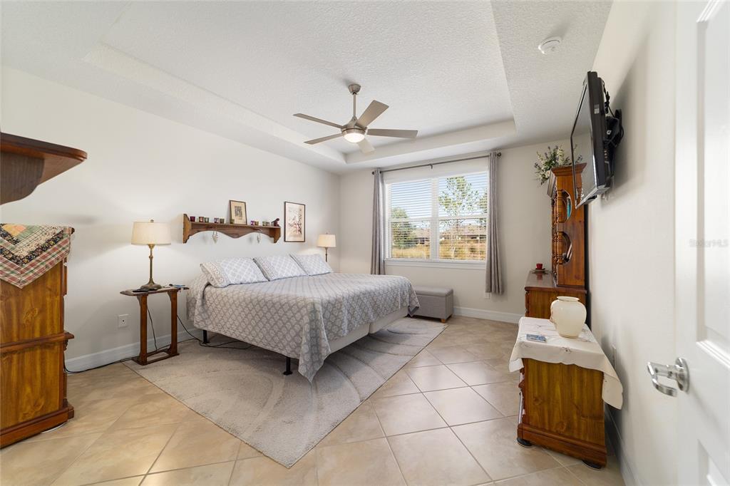 9603 Southwest 67th Street Ocala, FL 34481 - Photo 23 of 63 a bedroom with a bed and a flat tv screen on the dresser