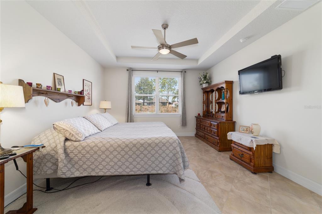 9603 Southwest 67th Street Ocala, FL 34481 - Photo 26 of 63 a bedroom with a bed a flat screen tv and dresser next to a window