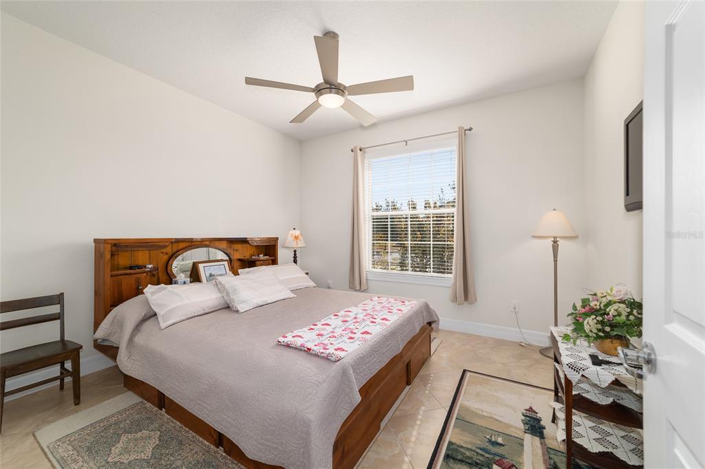 9603 Southwest 67th Street Ocala, FL 34481 - Photo 35 of 63 a bedroom with a bed and a chandelier