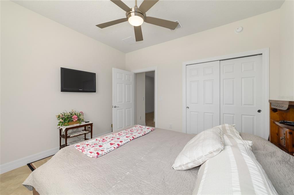 9603 Southwest 67th Street Ocala, FL 34481 - Photo 37 of 63 a bedroom with a bed and a flat screen tv