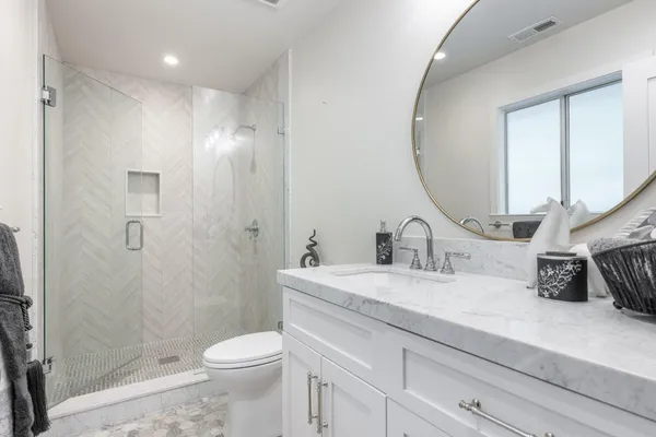 a bathroom with a sink a toilet and shower