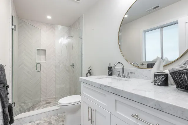 a bathroom with a sink a toilet and shower