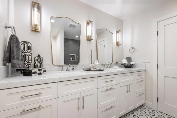 a bathroom with white cabinets and a sink