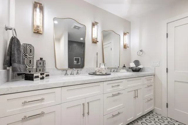a bathroom with white cabinets and a sink