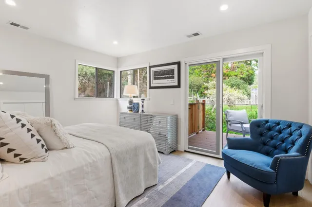 a bedroom with a bed couch and a large window