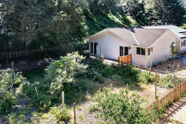 a aerial view of a house with a yard and sitting area